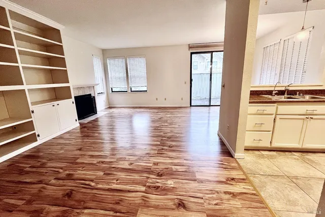 a view of a kitchen with wooden floor and cabinets