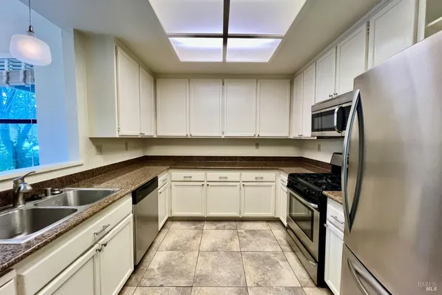 a kitchen with stainless steel appliances granite countertop a sink and a stove