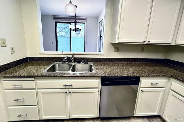 a kitchen with granite countertop cabinets sink and window