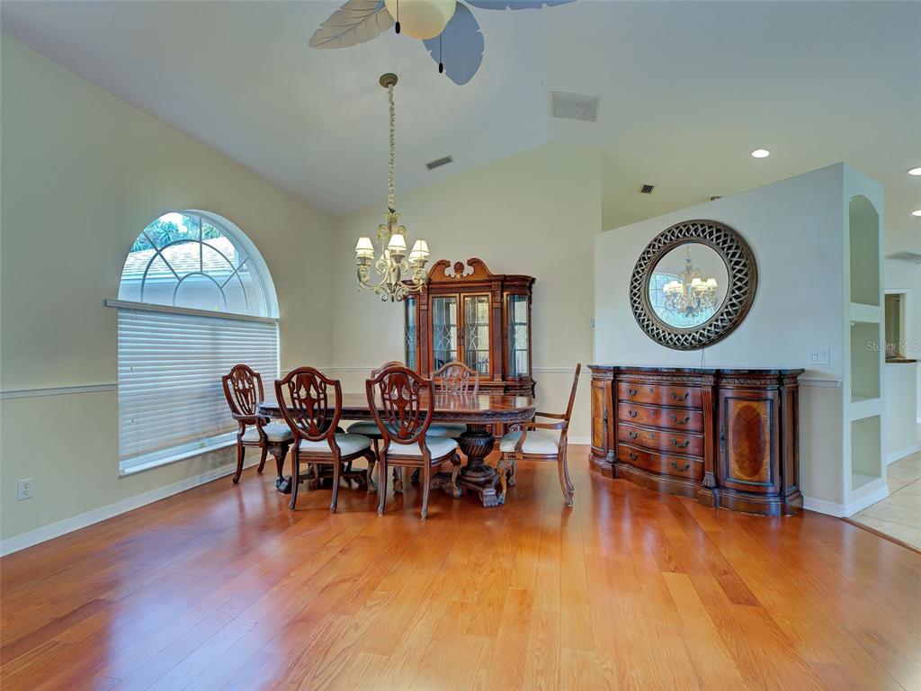 6265 Pheasant Road Venice, FL 34293 - Photo 22 of 70 a view of a dining room with furniture a chandelier and wooden floor
