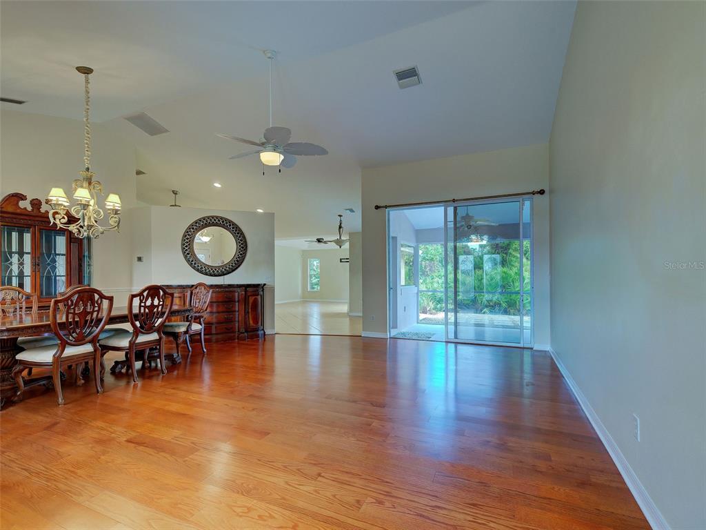 6265 Pheasant Road Venice, FL 34293 - Photo 23 of 70 a view of a dining room with furniture a chandelier and wooden floor