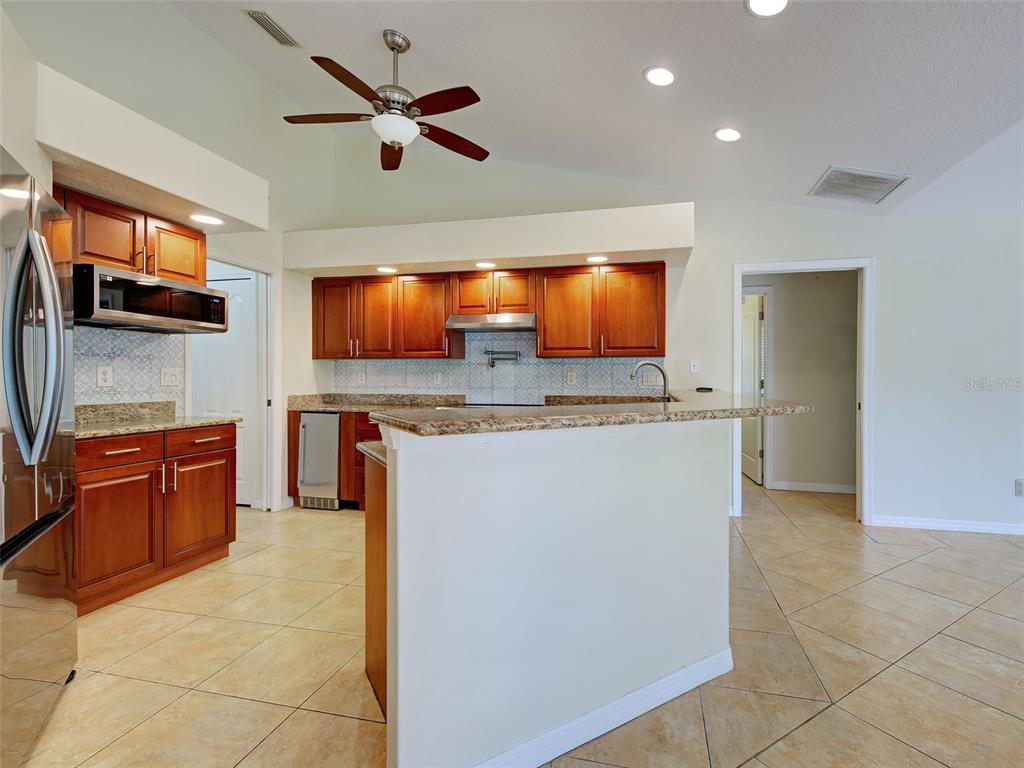 6265 Pheasant Road Venice, FL 34293 - Photo 43 of 70 a kitchen with stainless steel appliances kitchen island granite countertop a refrigerator and a stove top oven