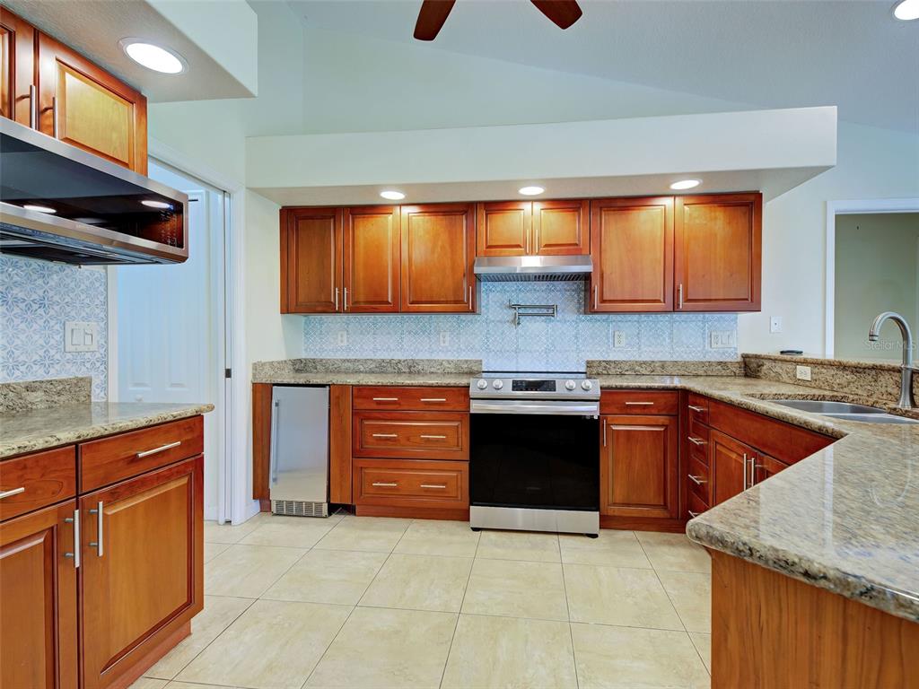 6265 Pheasant Road Venice, FL 34293 - Photo 44 of 70 a kitchen with granite countertop a sink and a stove
