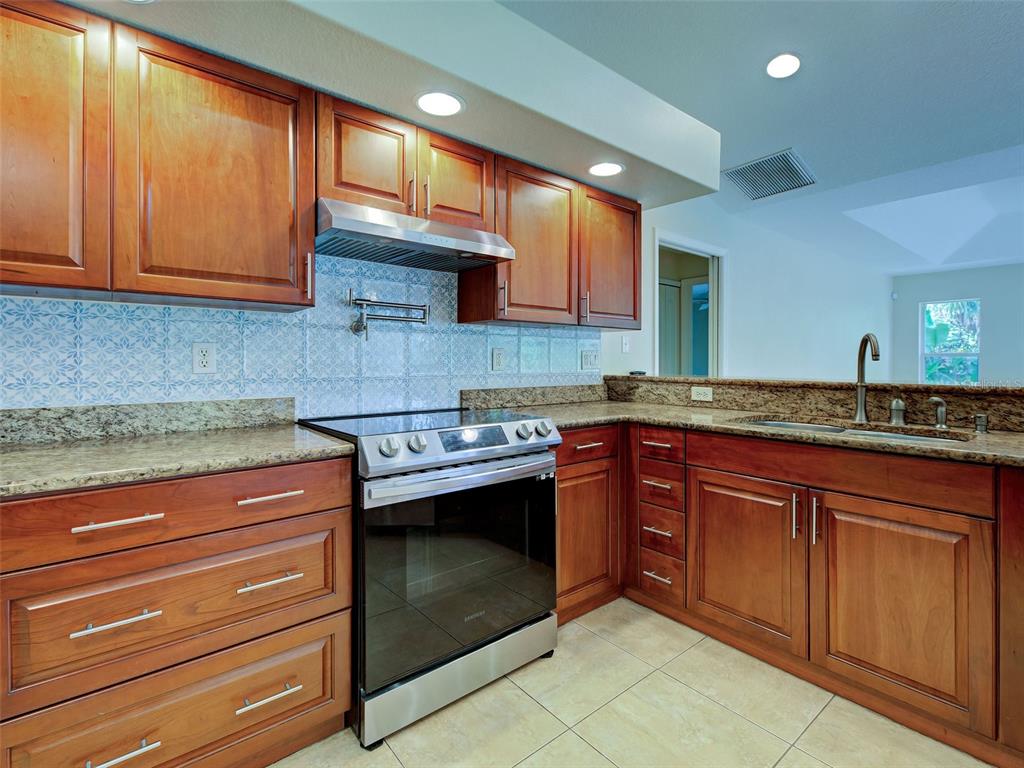6265 Pheasant Road Venice, FL 34293 - Photo 45 of 70 a kitchen with stainless steel appliances granite countertop a sink and cabinets