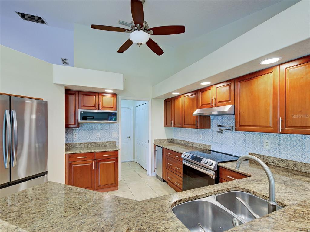 6265 Pheasant Road Venice, FL 34293 - Photo 47 of 70 a kitchen with stainless steel appliances granite countertop a sink and a microwave