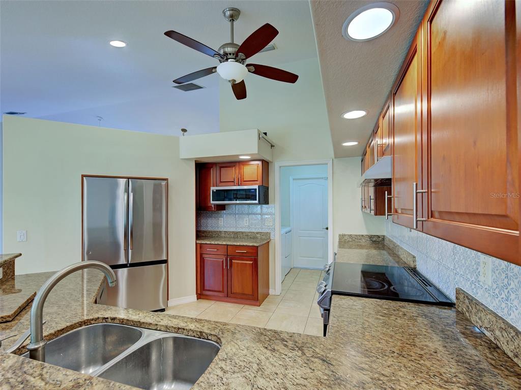 6265 Pheasant Road Venice, FL 34293 - Photo 48 of 70 a kitchen with stainless steel appliances granite countertop a sink and a microwave