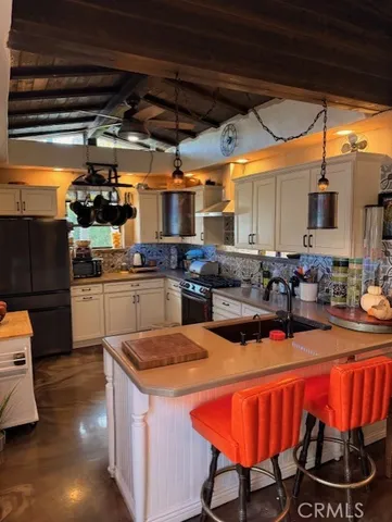 a kitchen with stainless steel appliances granite countertop a sink a stove a refrigerator a microwave oven with wooden floor