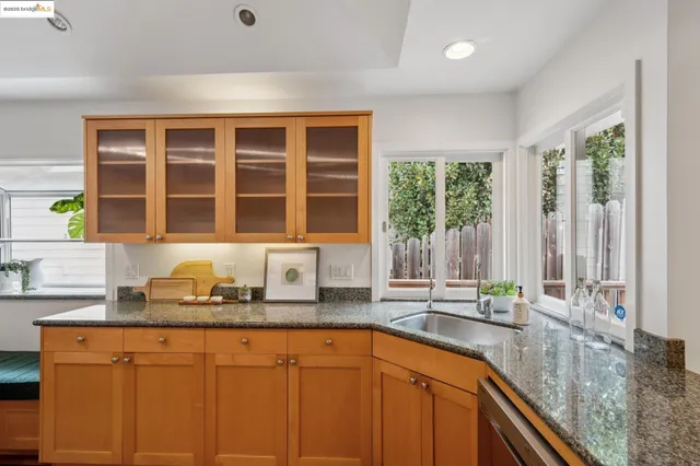 a kitchen with stainless steel appliances granite countertop a stove a refrigerator a dining table and chairs with wooden floor