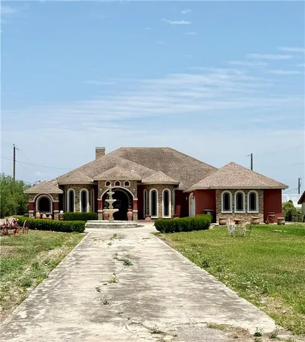 a front view of a building with a garden