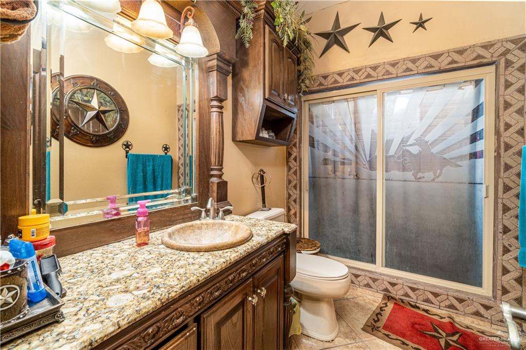 426 North FM 649 Rio Grande City, TX 78582 - Photo 8 of 16 a bathroom with a granite countertop sink mirror vanity and toilet