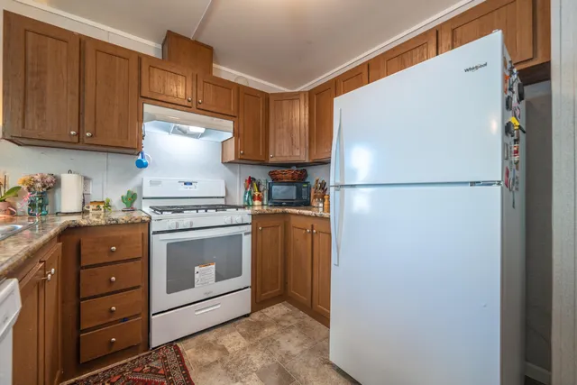 a kitchen with appliances a refrigerator and cabinets