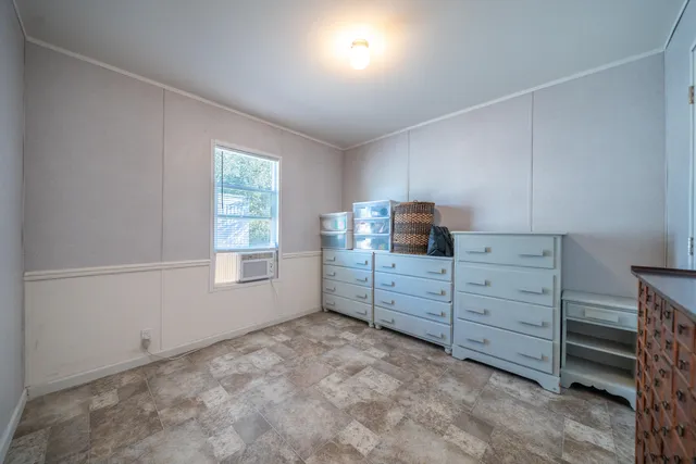 a room with a baby crib cabinets and a window