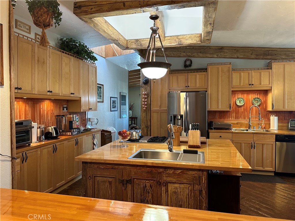 57260 Ramsey Road Anza, CA 92539 - Photo 15 of 44 a kitchen with stainless steel appliances wooden cabinets a sink and a stove