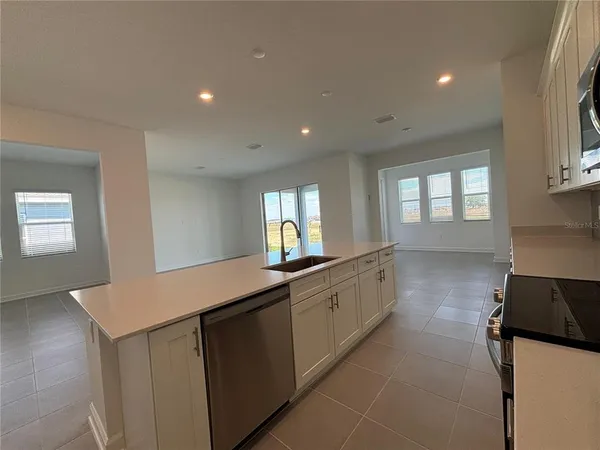 a kitchen with granite countertop a sink and a stove top oven