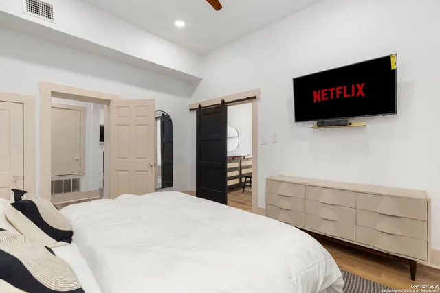 a bedroom with a bed and a flat screen tv