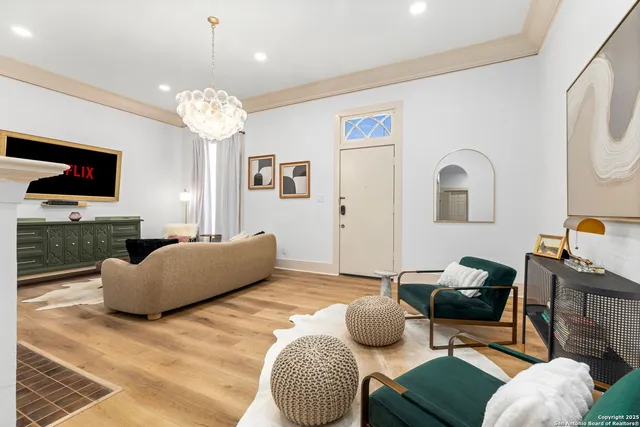 a living room with furniture a flat screen tv and a chandelier