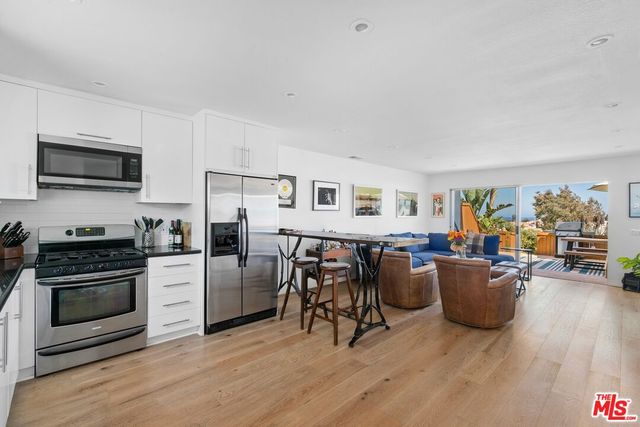 a living room with furniture a flat screen tv and a stove