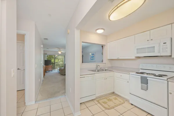 a kitchen with white cabinets and white appliances
