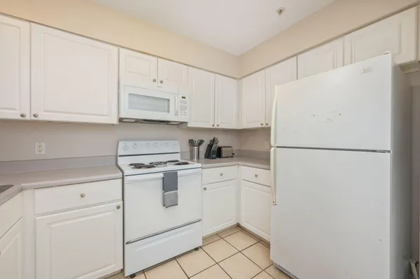 a kitchen with white cabinets and white appliances