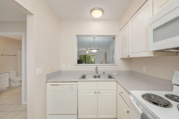 a view of a sink and dishwasher with white cabinets