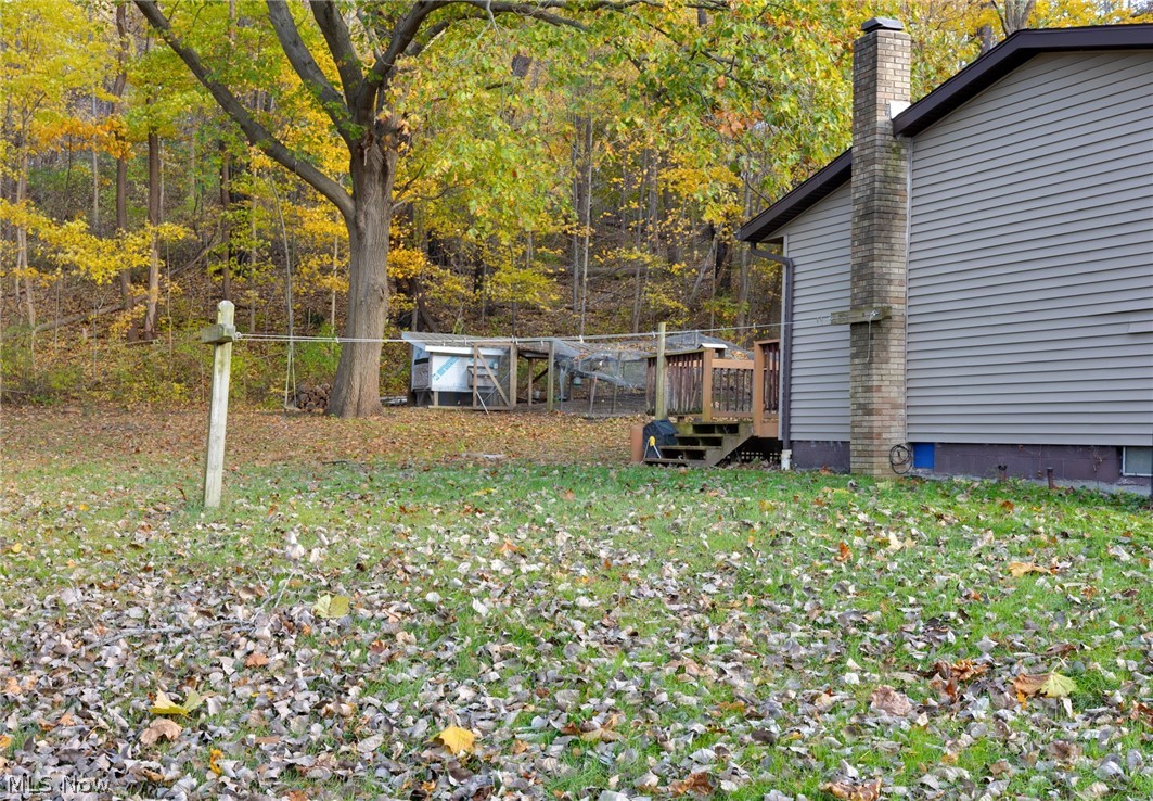 9416 Kieffer Road Mantua, OH 44255 - Photo 5 of 29 View of green lawn featuring a deck and a forest view