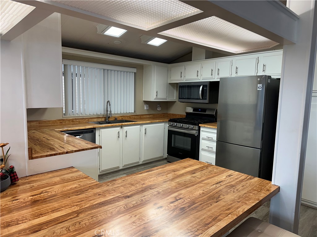 27701 Murrieta Road, Unit 268 Menifee, CA 92586 - Photo 9 of 24 a kitchen with stainless steel appliances granite countertop a refrigerator sink and cabinets
