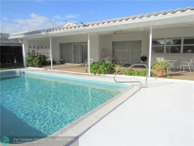 a view of a hallway with dining area and chandelier