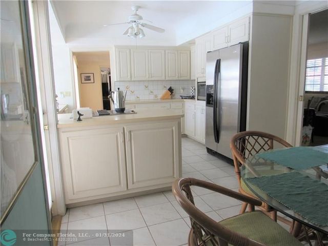 a kitchen with stainless steel appliances granite countertop a sink a refrigerator and a stove