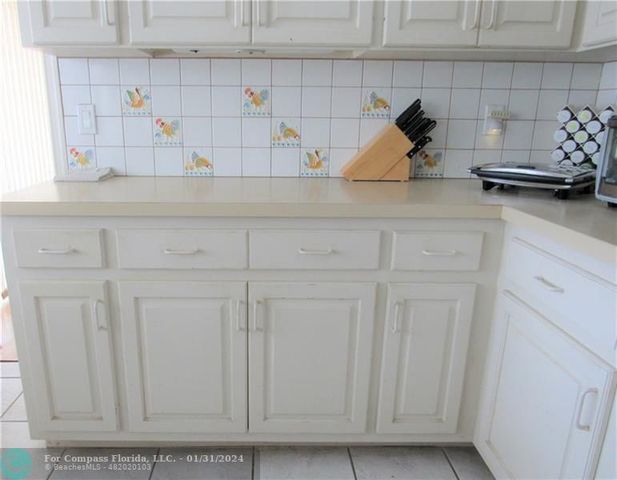 a kitchen with white cabinets and a sink
