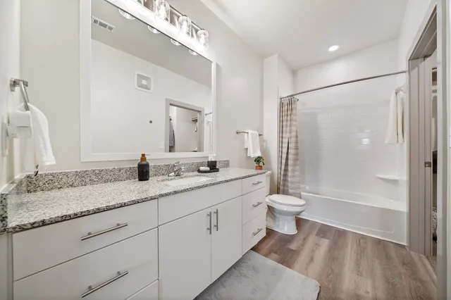 a bathroom with a double vanity sink toilet and shower
