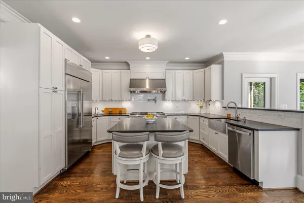 a kitchen that has a lot of cabinets in it and stainless steel appliances