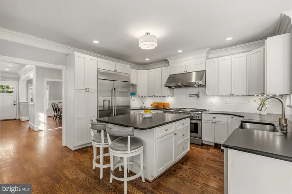 a kitchen with stainless steel appliances granite countertop a sink refrigerator and cabinets