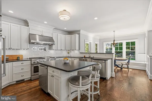 a kitchen with a sink a counter top space stainless steel appliances and cabinets