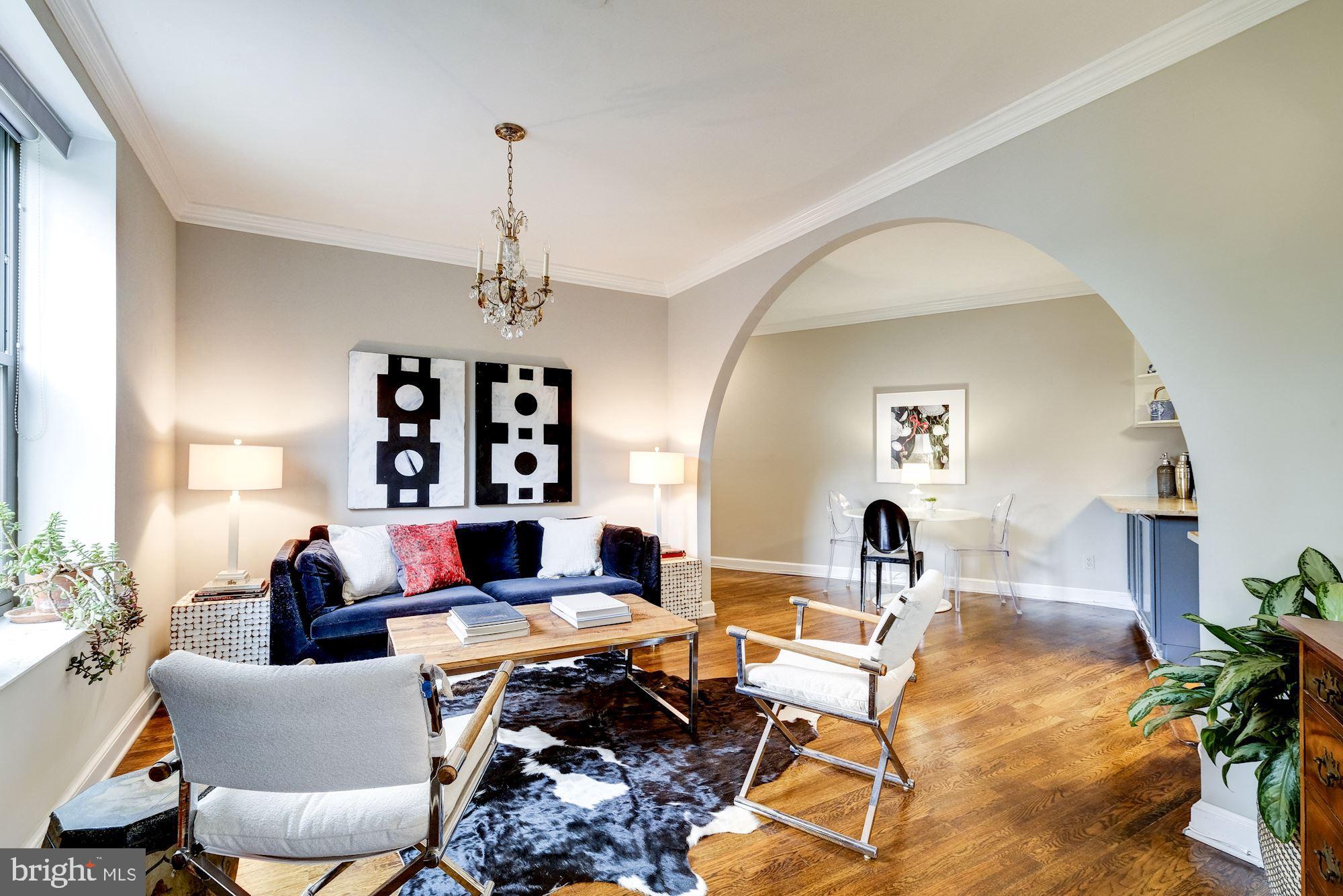 a living room with furniture a window and a chandelier