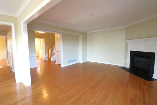 a view of empty room with wooden floor and fireplace