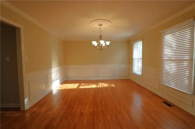 a view of a room with wooden floor and large windows