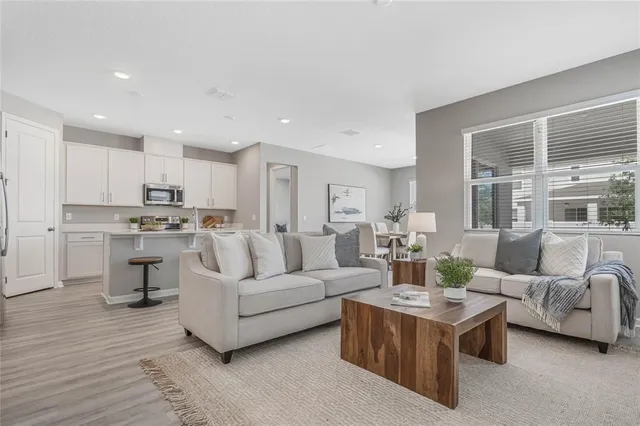a living room with furniture and view of kitchen