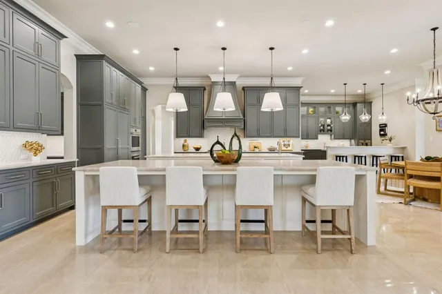 a dining area with stainless steel appliances kitchen island granite countertop a table chairs and a kitchen view