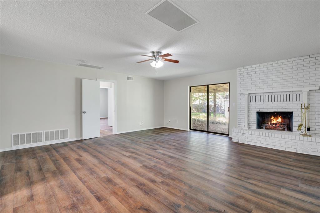 209 Mistletoe Lane Keene, TX 76059 - Photo 8 of 38 a view of an empty room with chandelier fan and wooden floor