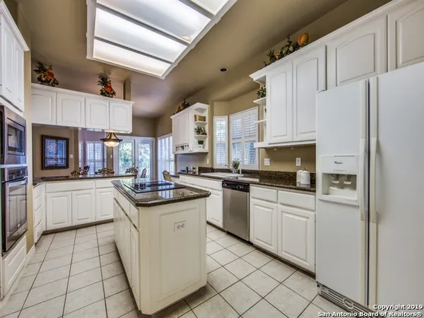 a kitchen with granite countertop appliances cabinets and furniture