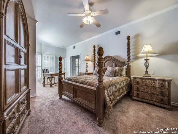 a bedroom with a bed a chandelier and dresser