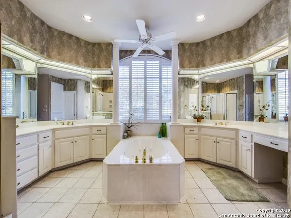 a large spacious bathroom with a granite countertop sink mirror and bathtub