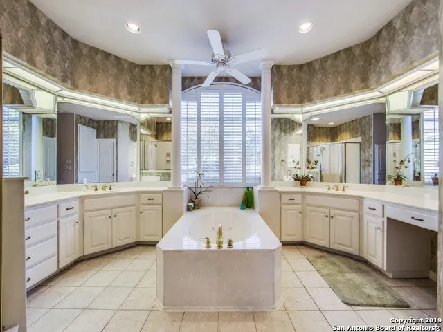 a large spacious bathroom with a granite countertop sink mirror and bathtub