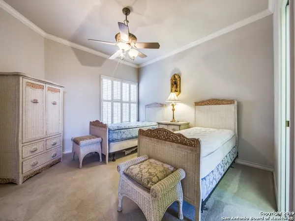 a bedroom with a bed chandelier and a window