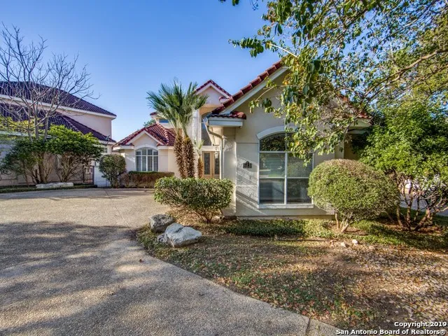 a front view of a house with a yard and potted plants
