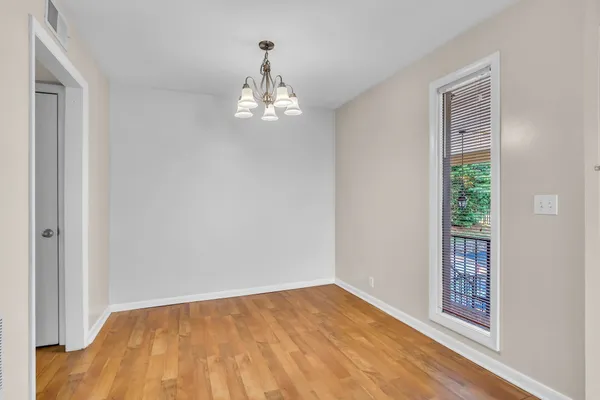 a view of a dining room with furniture wooden floor and a chandelier