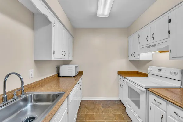 a kitchen with granite countertop a sink stove and refrigerator