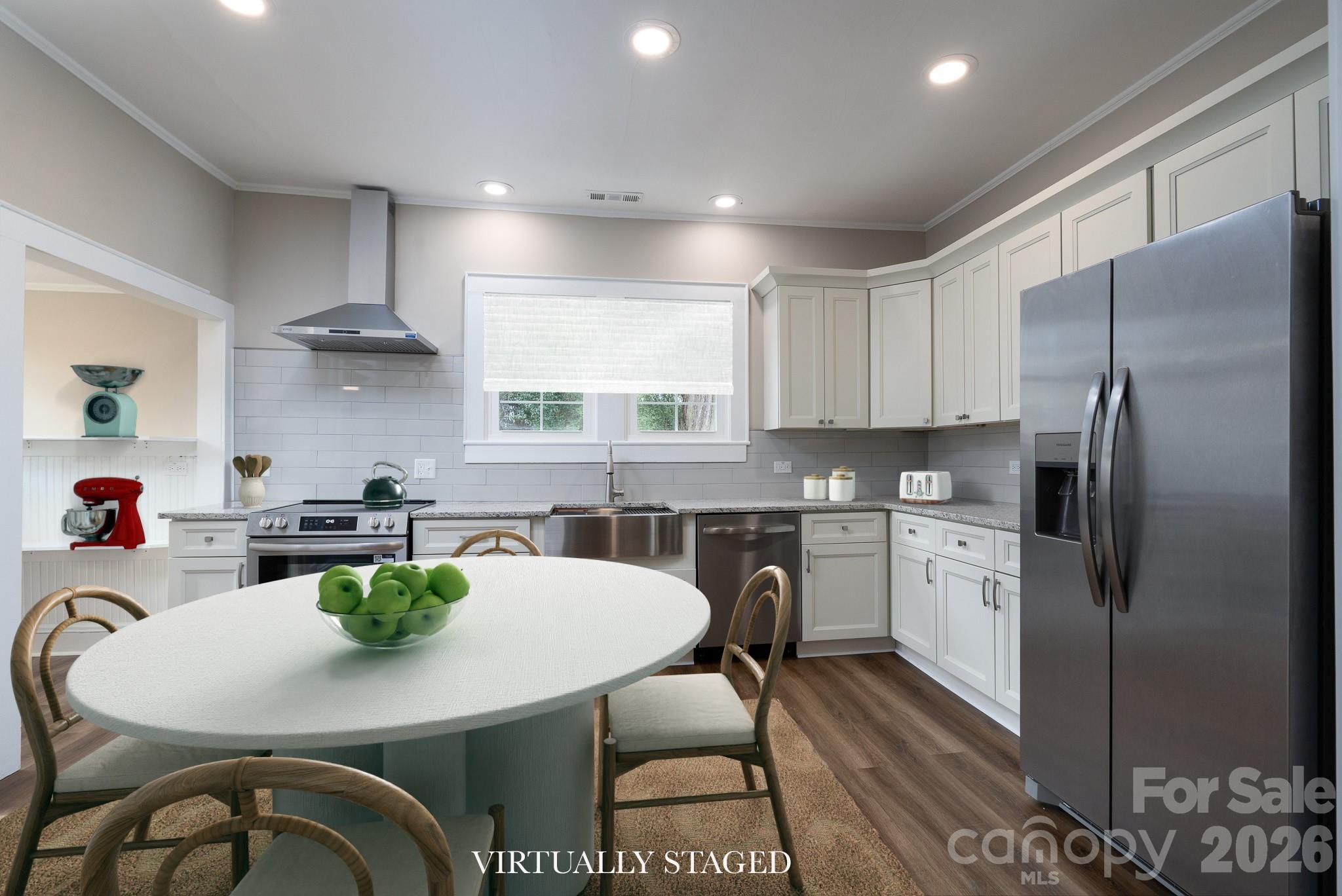 61 3rd Street Northwest Concord, NC 28027 - Photo 11 of 40 a kitchen with stainless steel appliances a dining table chairs refrigerator and sink