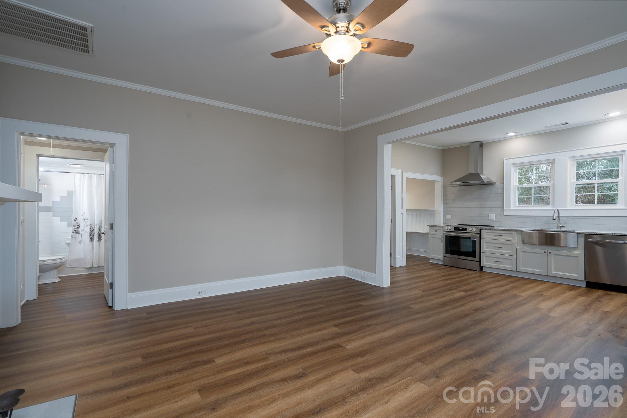 61 3rd Street Northwest Concord, NC 28027 - Photo 9 of 40 a view of a kitchen with wooden floor and a ceiling fan