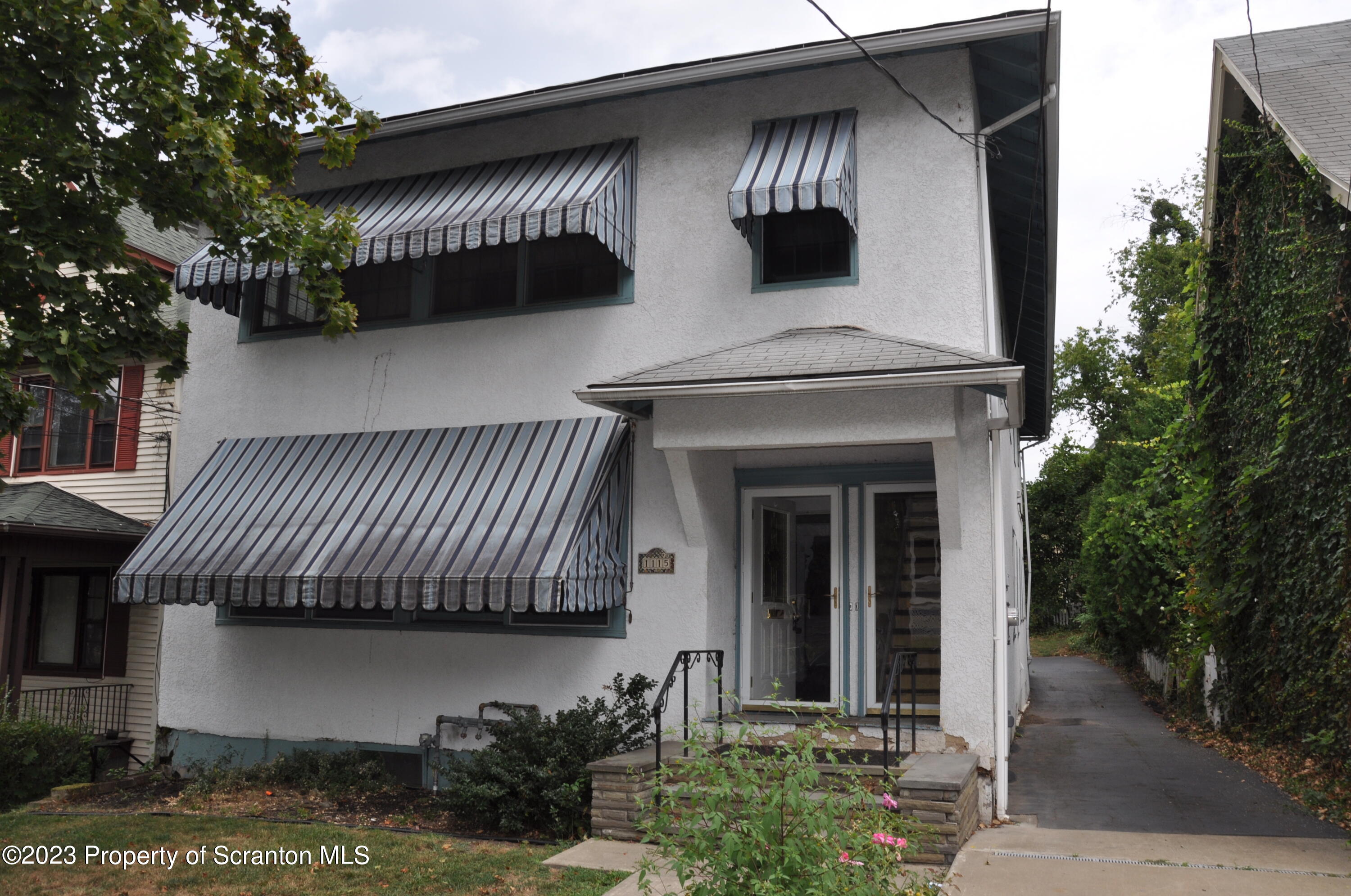 1115 Fisk Street Scranton, PA 18509 - Photo 1 of 4 a front view of a house with a garden